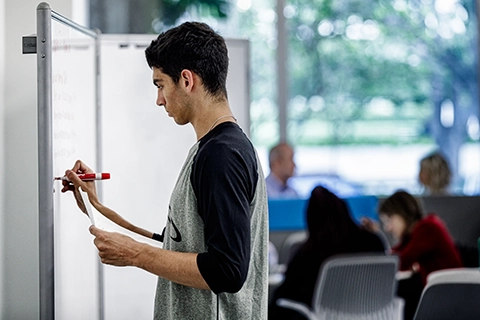 student planning out a project at a whiteboard
